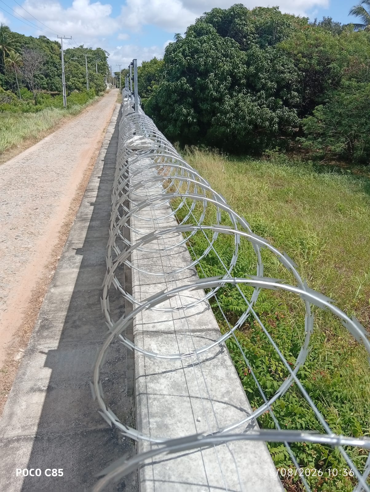 Detalhe da concertina instalada sobre muro perimetral em área de mata