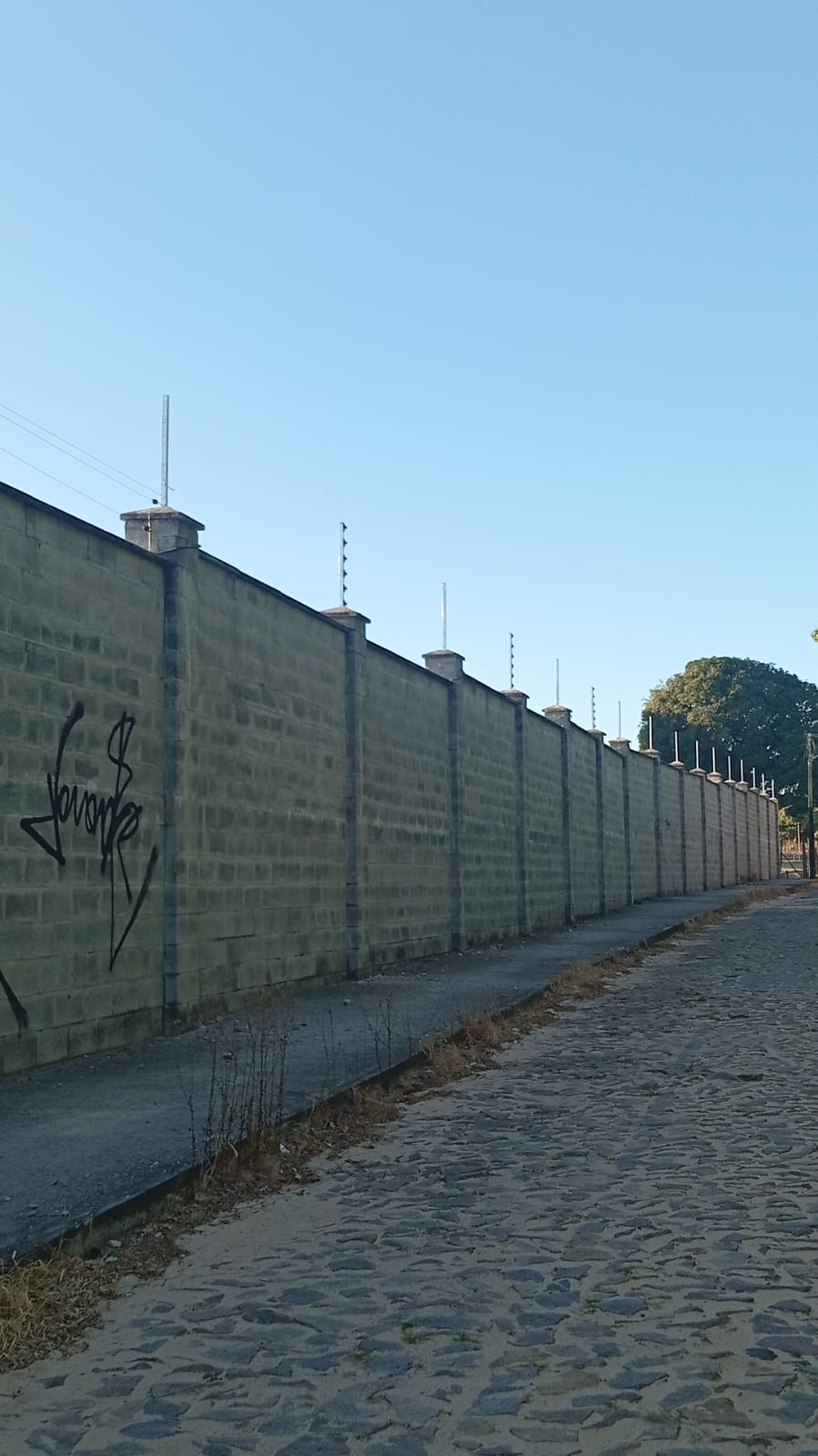 Cerca elétrica com concertina cobrindo extenso perímetro - projeto de grande porte